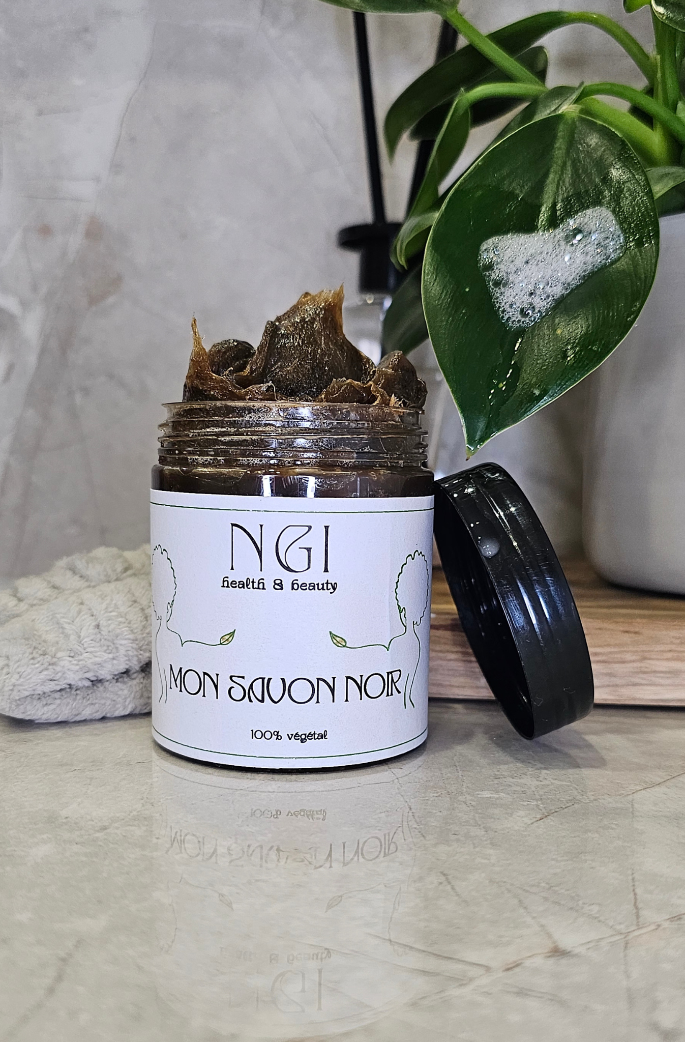 Savon noir en pâte 100% végétal dans un pot ouvert, offrant une texture riche et moussante pour un soin exfoliant naturel. Idéal pour une peau douce et purifiée.