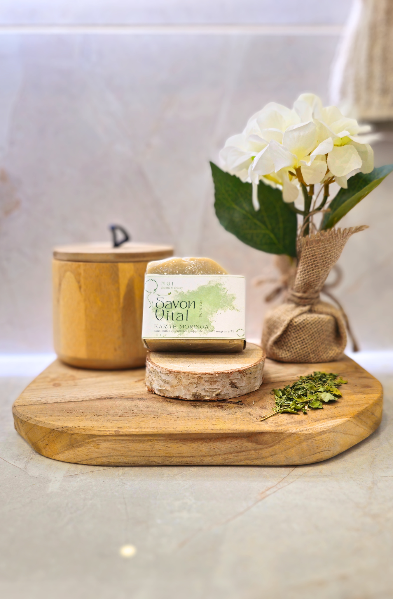 Savon Karité/Moringa présenté sur un plateau en bois avec poudre de feuille de moringa, idéal pour un soin nourrissant et revitalisant au quotidien.